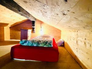 Zimmer mit einem roten Bett in einem Holzzimmer in der Unterkunft Zum Stillen Unicum in Axalp