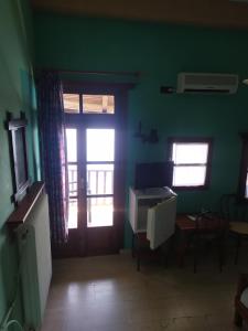 Habitación con paredes verdes y puerta con ventana en Double studio room in Mylopotamos with beautifull view, en Tsagkarada