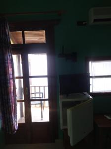 Habitación con puerta, 2 ventanas y escritorio. en Double studio room in Mylopotamos with beautifull view, en Tsagkarada