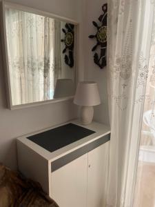 biała komoda z lustrem i lampą w obiekcie Apartment Goya w mieście Torrevieja
