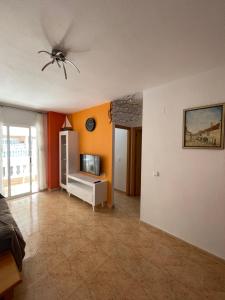salon z pomarańczowymi ścianami i wentylatorem sufitowym w obiekcie Apartment Goya w mieście Torrevieja