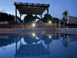 a swimming pool at night with lights in the water at Quinta da Layla in Olhão