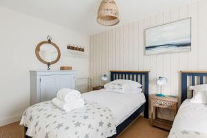 a bedroom with two beds and a mirror at Lobster Cottage in Poole