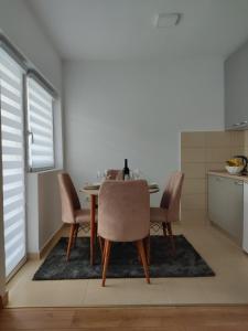 einen Esstisch und Stühle in der Küche in der Unterkunft Apartman Andjela in Plužine