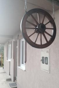 une grande roue en bois suspendue à un mur dans l'établissement Apartman Đoladuma, à Gacko
