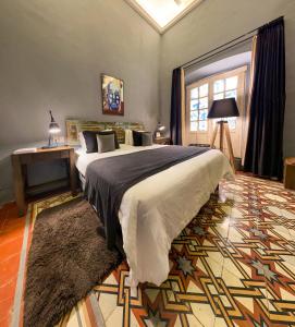 Un dormitorio con una cama grande y una ventana en Hotel Nena Centro, en San Miguel de Allende