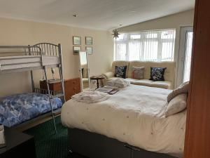 a bedroom with a bunk bed and a couch at Grockle Nook Holiday Apartment in Brixham