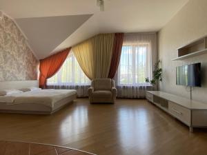 - une chambre avec un lit, une télévision et une chaise dans l'établissement Parus, à Tchernivtsi