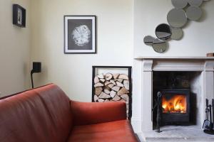 a living room with a couch and a fireplace at A beautiful Georgian town house in Painswick in Painswick