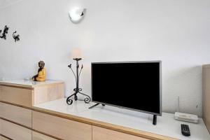 telewizor z płaskim ekranem siedzący na komodzie w obiekcie estudio Los Cristianos-Tenerife- w mieście Los Cristianos