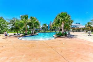 uma piscina com palmeiras num resort em Windmark - Sea Grove Guesthouse em Saint Joe Beach