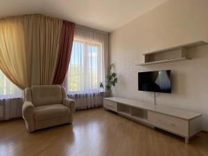 a living room with a television and a chair at Parus in Chernivtsi