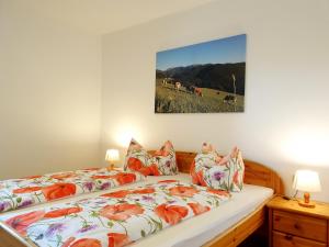 a bedroom with two beds and a painting on the wall at Bauernhof Pension Juri in Obergösel
