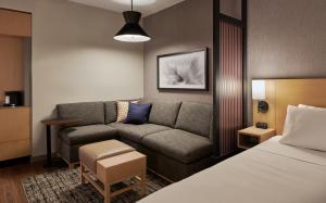 a living room with a couch and a bed at Hyatt Place Sacramento International Airport in Sacramento