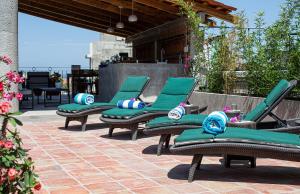 a group of green chairs sitting on a patio at Casitas Miramar Puerto Vallarta Malecón in Puerto Vallarta