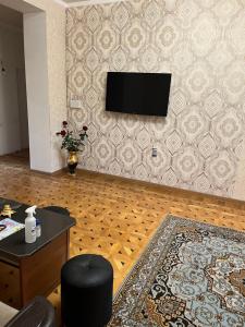 a living room with a flat screen tv on a wall at Guest House SAMAN in Garni