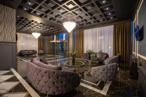 a lobby with couches and a table and chairs at Volga Hotel Baku in Baku