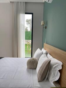 a bedroom with a bed with white pillows and a window at Solin House in Kadıköy
