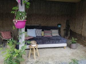 a bed in a tent with a table and plants at La romance de Laura in Arrest