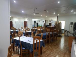 a dining room with tables and chairs and a kitchen at Hotel Ribeira Grande in Ribeira Grande