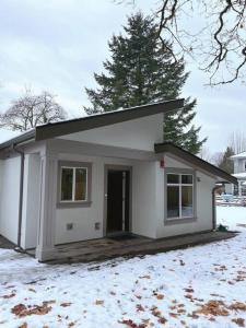 a small white house with snow on the ground at Entire Brand new 3 bed 2 bath Guesthouse in Vancouver