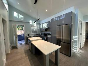 a kitchen with stainless steel appliances and a counter top at Entire Brand new 3 bed 2 bath Guesthouse in Vancouver