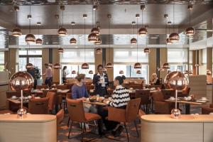 people sitting at tables in a restaurant at Maritim Hotel Ingolstadt in Ingolstadt +52 photos