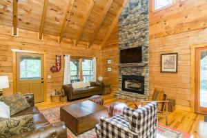 a living room with a stone fireplace in a cabin at New Listing! Lakeview Lodge - 5 Bed, 4 Bath - Hot Tub in Dahlonega