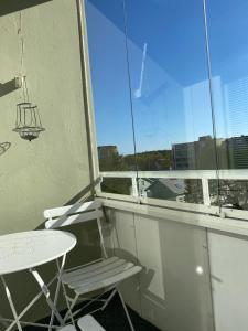 a balcony with a table and a chair and a window at City apartment Pikkuvuori in Turku