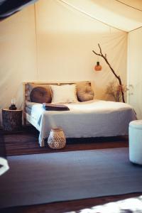 een slaapkamer met een bed met kussens erop bij Boho Park Glamping in Zawiszyn