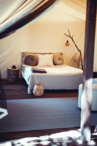 ein Schlafzimmer mit einem Bett in einem Zelt in der Unterkunft Boho Park Glamping in Zawiszyn