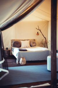 een slaapkamer met een bed in een tent bij Boho Park Glamping in Zawiszyn
