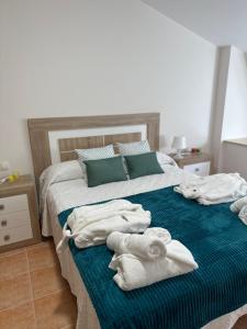 um quarto com uma cama com toalhas em Ático de Carmen em Cee