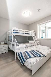 a bedroom with two bunk beds and a window at Lovely 2 bedroom suite steps from The beach in Victoria