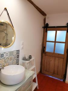 ein Badezimmer mit einem weißen Waschbecken und einer Tür in der Unterkunft chez Marie et Lulu 