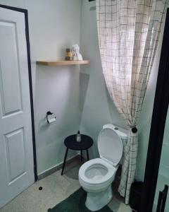 a bathroom with a white toilet and a table at Palm On Rock - 1 bedroom,kitchenette & full bathroom. in Bloemfontein