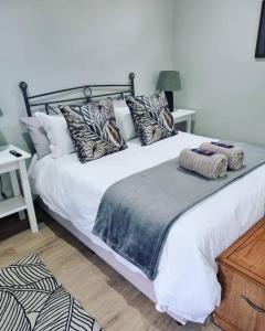 a bedroom with a large bed with pillows on it at Palm On Rock - 1 bedroom,kitchenette & full bathroom. in Bloemfontein