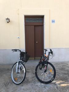 zwei Fahrräder, die vor einem Gebäude mit einer Tür geparkt sind in der Unterkunft IL GIARDINO DEL MANDARINO HOUSE in Montalbano