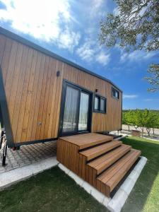 a small house with a deck and windows at Zu Tiny House Hotel & Restaurant in Urla