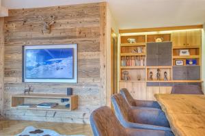 a living room with a wooden wall with a tv at Apartment Antonia - by Alpen Apartments in Zell am See