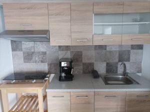 a kitchen with wooden cabinets and a sink at Emerald Suite Alonnisos in Patitiri