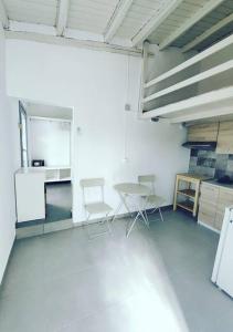 a kitchen with two chairs and a table in a room at Emerald Suite Alonnisos in Patitiri