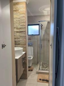 a bathroom with a shower and a sink and a toilet at Side Step in Johannesburg