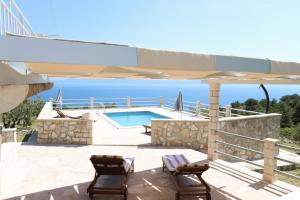 a swimming pool with two chairs and an umbrella at kamena kuća kanava in Selca