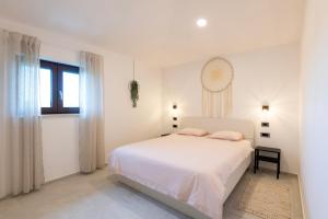 塔尔4 ELEMENTS - Luxury Family Apartments的一间白色的卧室，配有一张白色的床和一扇窗户
