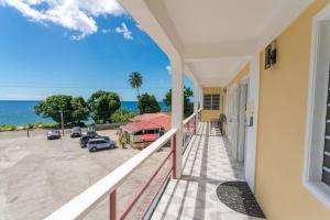 uma varanda com vista para um parque de estacionamento em VJ's Guesthouse Vacation Home, Jimmit, Dominica em Roseau