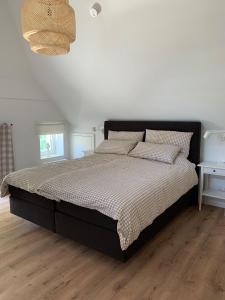 a bedroom with a bed with a black bed frame and pillows at Hygge-Huus-Burhave in Burhave