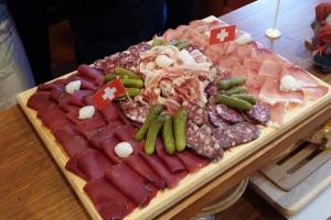 a tray of meats and vegetables on a table at Chalet le Grenier des Crosets in Champéry