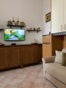 sala de estar con TV de pantalla plana en la pared en Le Bouganvillea, en Peschici