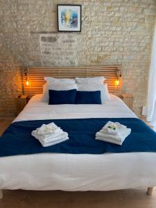 ein Schlafzimmer mit einem großen Bett mit Handtüchern darauf in der Unterkunft Au cocon de Bélice in Benon